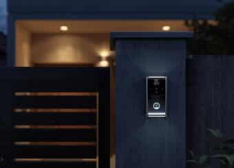 A modern house entrance in Pakistan at night with a smart video door bell and intercom system installed