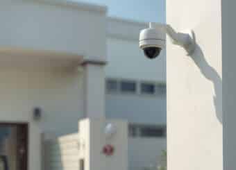 A realistic image of a modern home and small business protected with CCTV cameras,