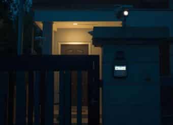 A realistic photo of a Pakistani house at night with a modern home security system installed.